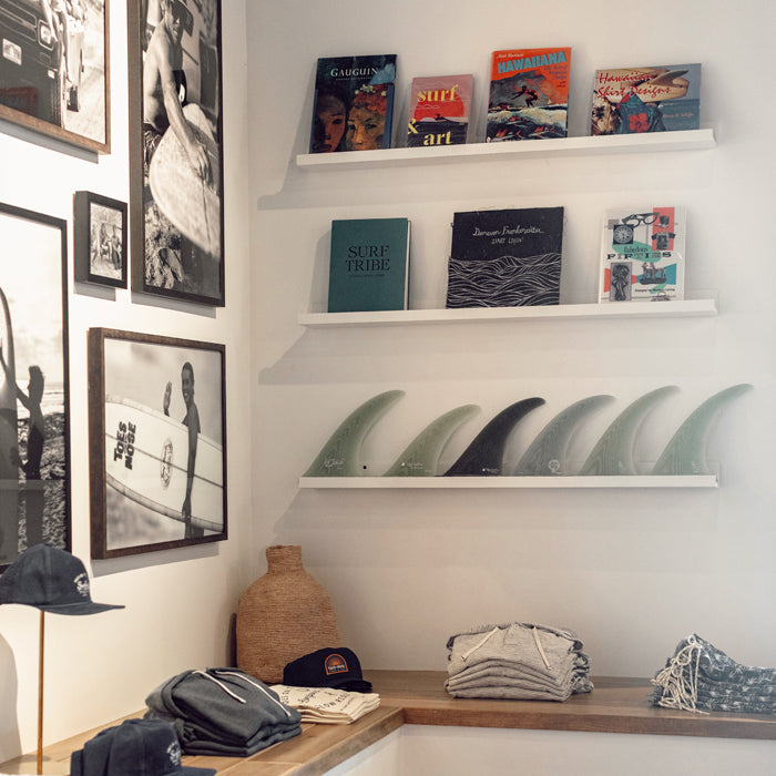 Shelves with surf memorabilia, books, and lifestyle accessories at San Juan Capistrano Toes on the Nose