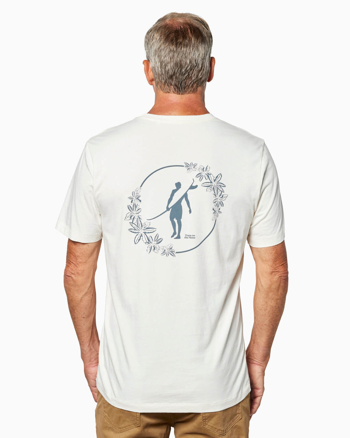 Man wearing a natural t-shirt with a graphic Toes on the Nose design on the back, standing against a white background #color_natural