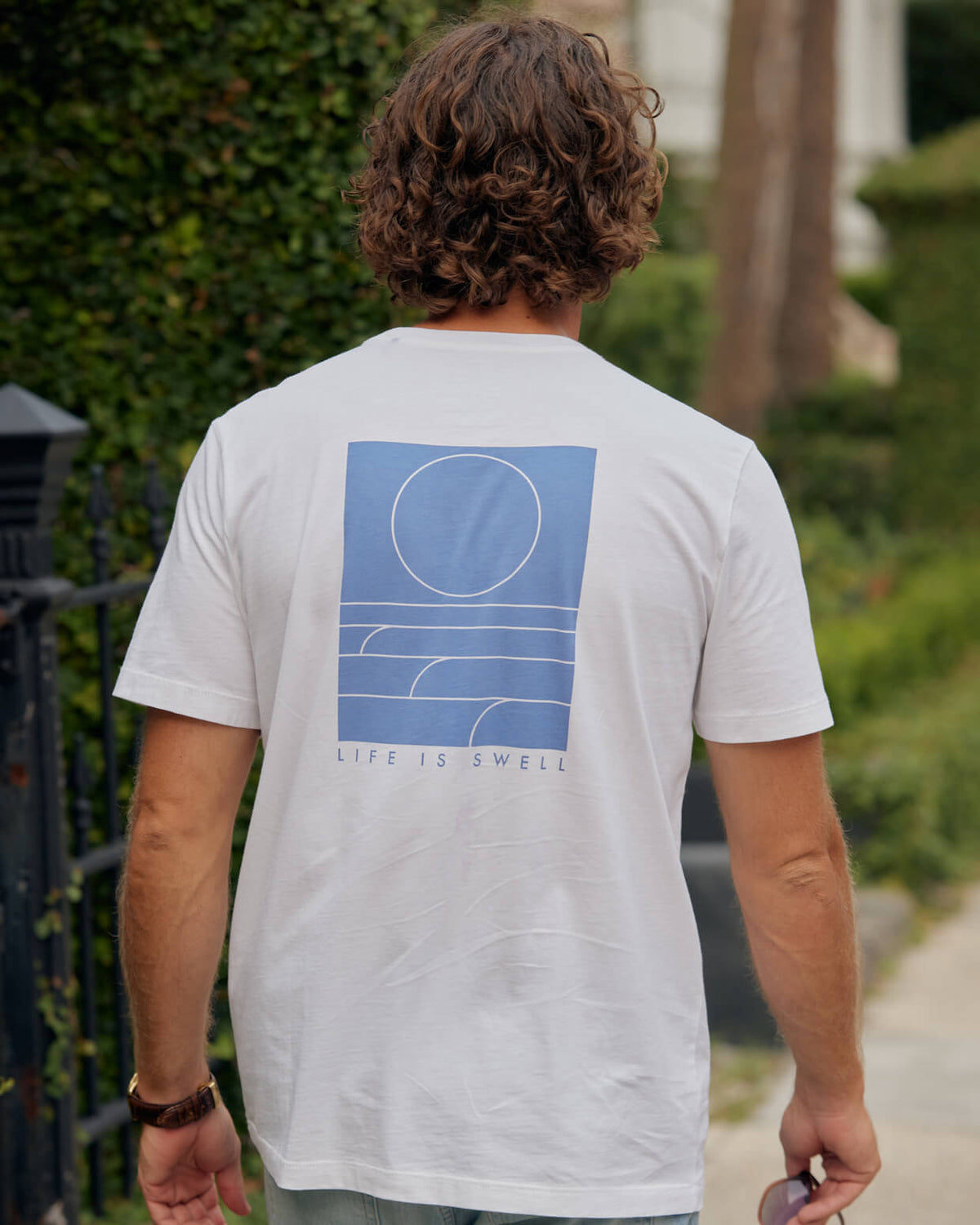 Men's white life is swell Toes on the Nose, worn in a lifestyle setting outdoors.