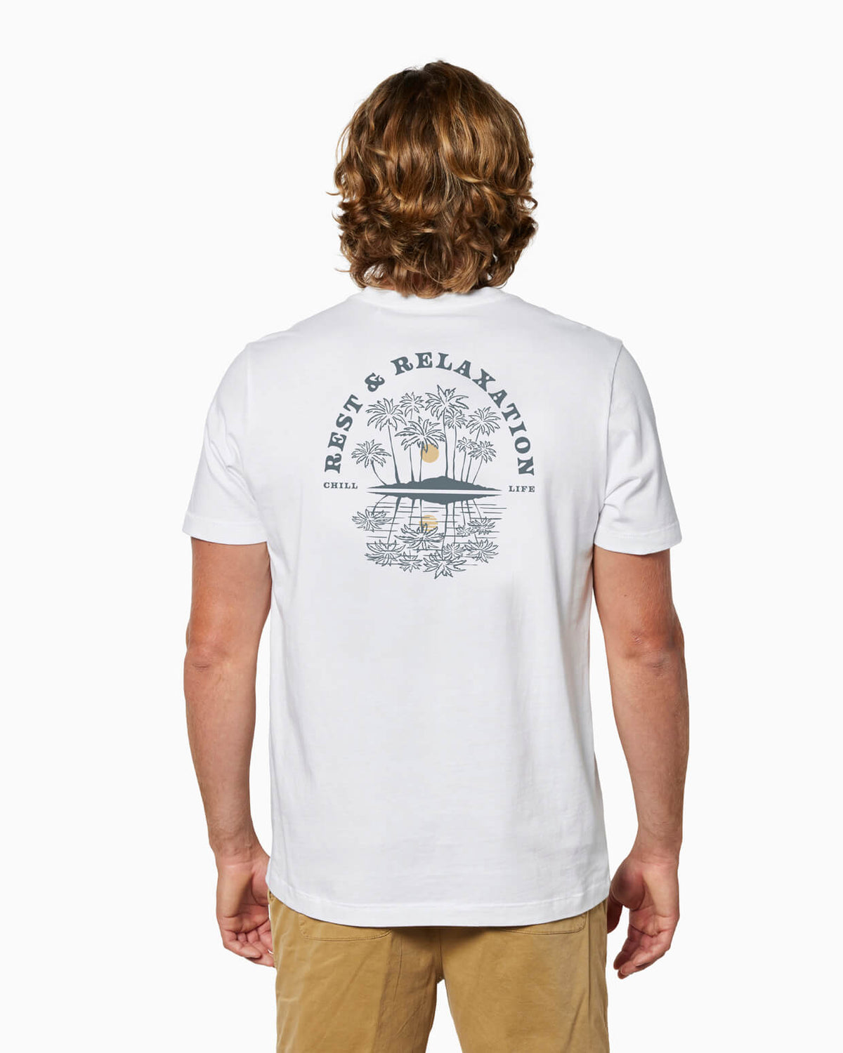 Man wearing a white t-shirt with rest and relaxation design with palm trees and a sun, standing against a white background. #color_white