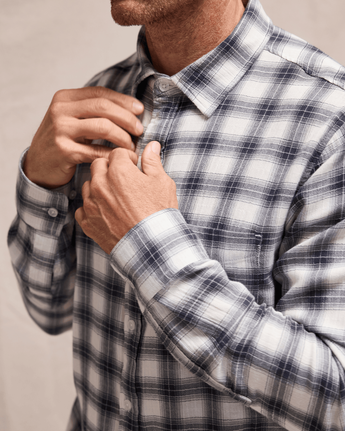 Person wearing a plaid shirt with a neutral background #color_deuce navy