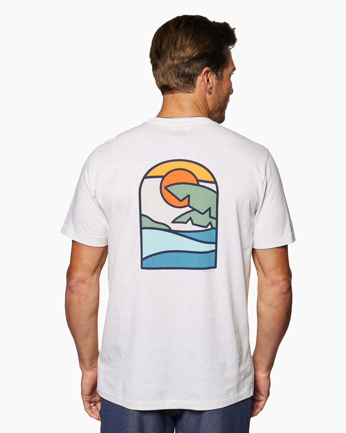 Men's white t-shirt with a colorful sunset and ocean wave graphic on the back, angled view.