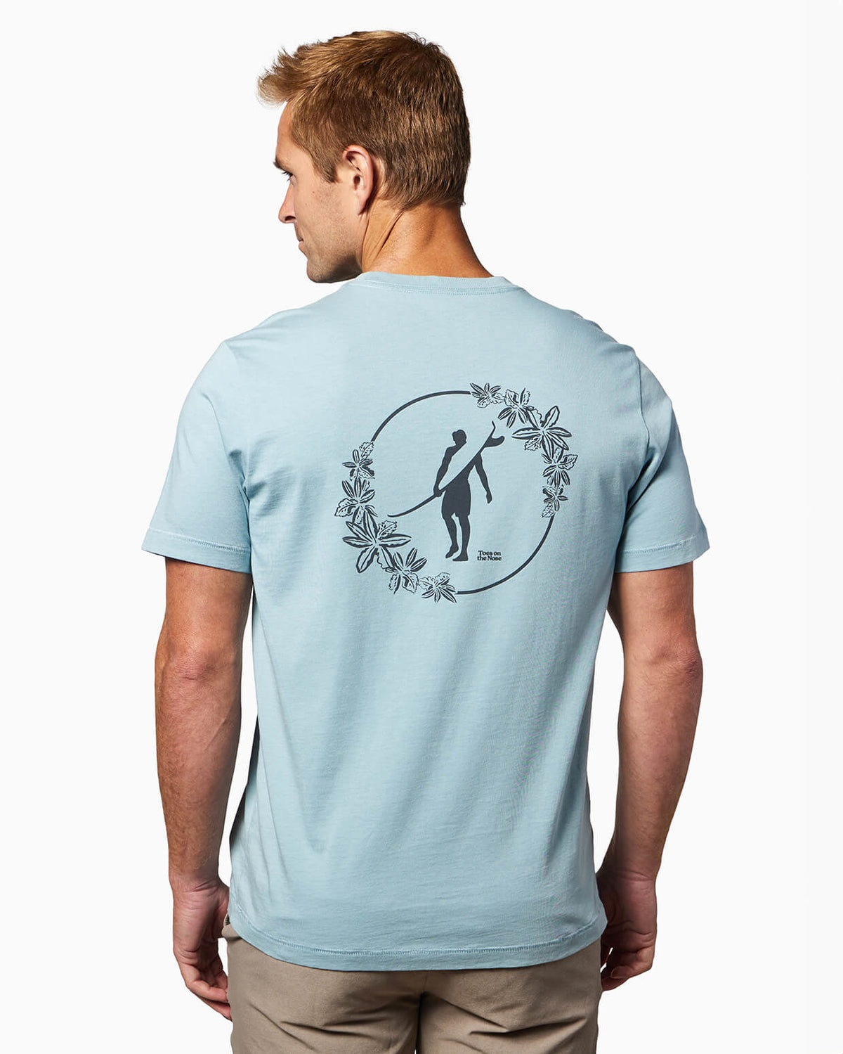 Men's light blue t-shirt with Toes on the Nose logo surrounded by floral design on the back, worn by a model with a clean background.