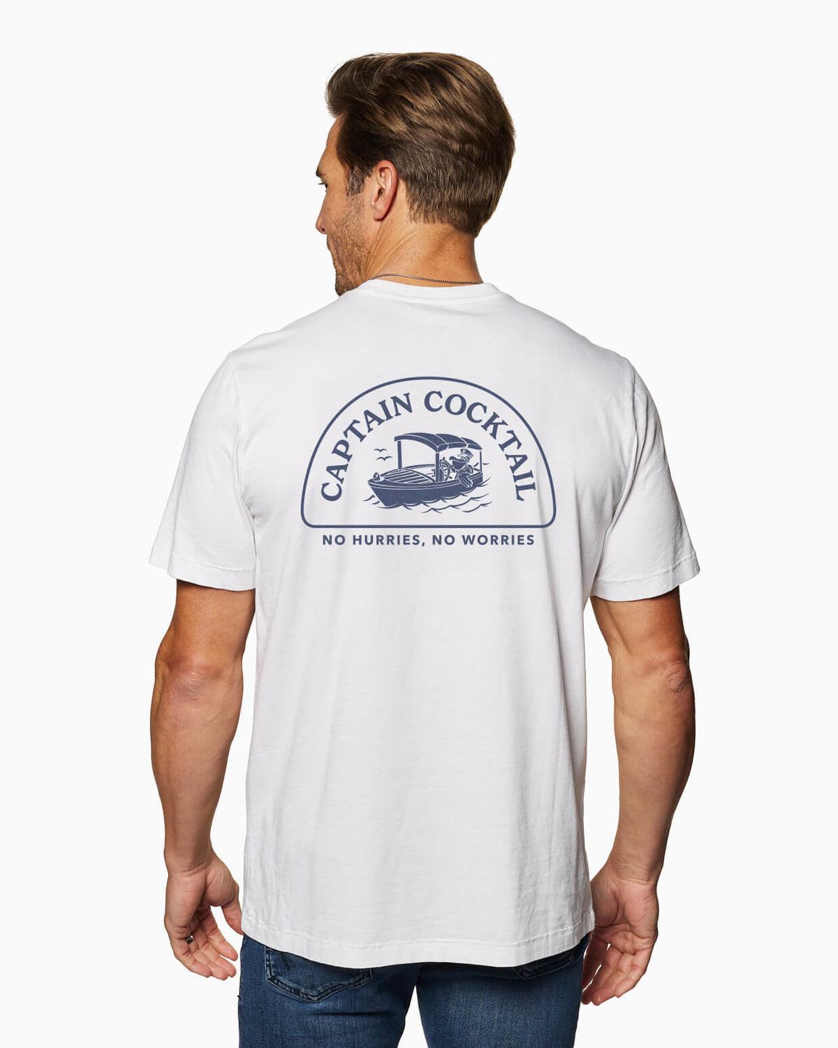 Men's white t-shirt with blue Captain Cocktail logo and boat graphic, worn with jeans on a plain background.
