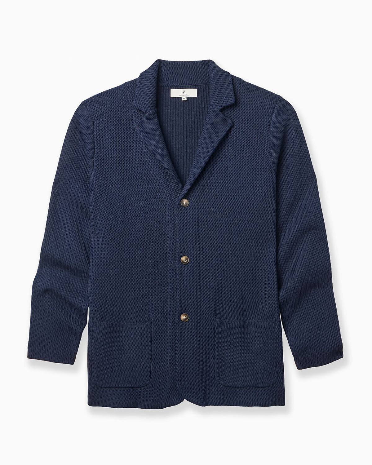 A navy blue textured knit cardigan sweater with notched lapels, three front buttons, and two front patch pockets, shown on a clean white background. #color_estate cardigan
