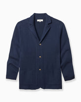 A navy blue textured knit cardigan sweater with notched lapels, three front buttons, and two front patch pockets, shown on a clean white background. #color_estate cardigan