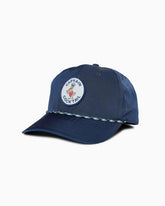 Navy “Captain Cocktail” baseball cap with embroidered duck patch and braided rope across brim, angled studio view.