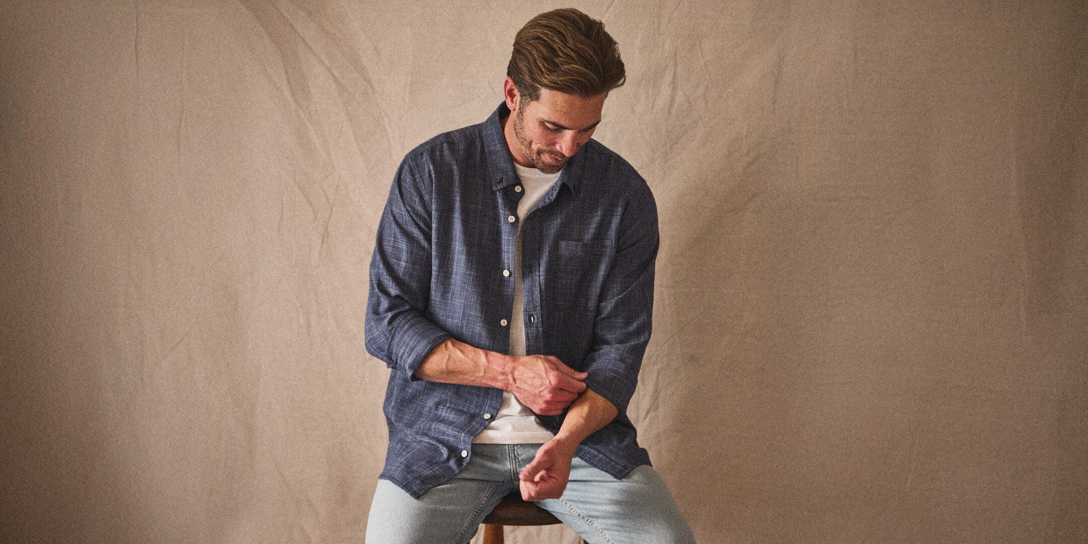 Man wearing a navy button-up with canvas background showcasing style of Toes on the Nose new arrivals in desktop view